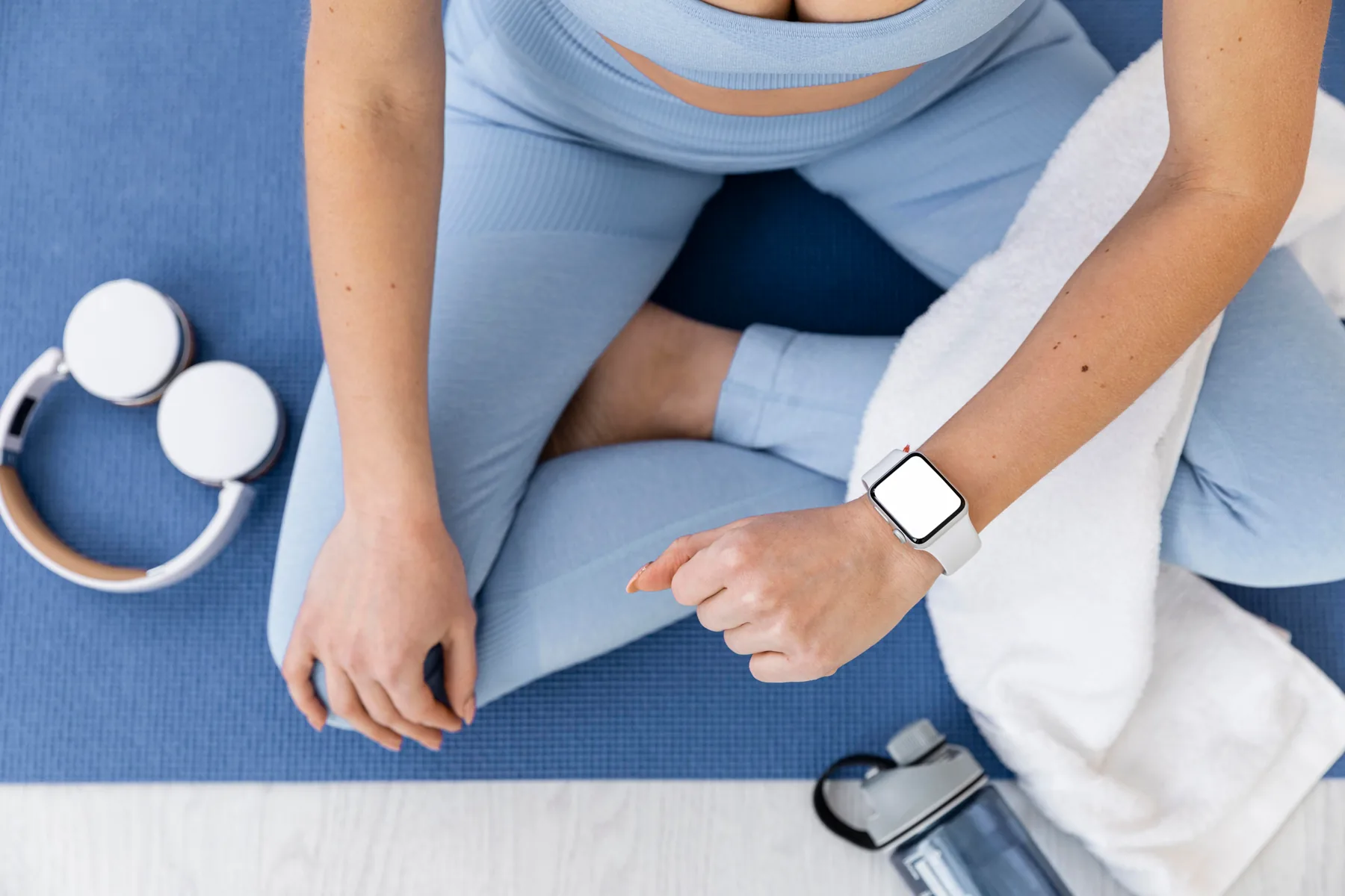 Woman on a yoga mat with wellness essentials